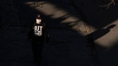 Un hombre protegido con mascarilla camina por el paso fronterizo hacia Estados Unidos de San Ysidro, en Tijuana, México, el 23 de abril de 2020.  El presidente Donald Trump ha bloqueado parcialmente la inmigración a Estados Unidos 