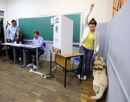 Eleitora com cão guia comemora após votação em Belo Horizonte.