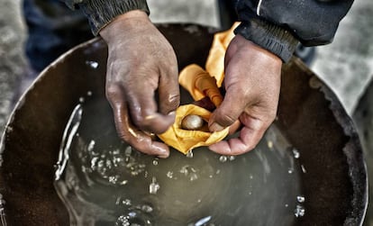 Con un pañuelo se filtra el agua hasta que queda en la mano una pequeña bola de mercurio y oro.