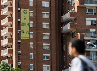 Un joven ante un edificio de pisos de alquiler de Barcelona, en una imagen de archivo.