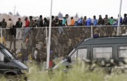 Inmigrantes subsaharianos que permanecían encaramados a la valla de Melilla, tras protagonizar un intento de entrada masivo a la ciudad.