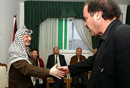 Arafat saluda al cineasta Oliver Stone en su oficina, durante la visita de la delegación del Parlamento de Escritores a Ramala. En segundo plano, Saramago y Goytisolo.