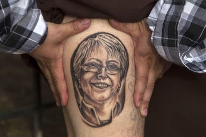 Un hombre muestra un tatuaje con el rostro de Bachelet.