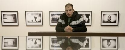 Dimitri Stefanov, junto a las fotografías de su exposición en Madrid.