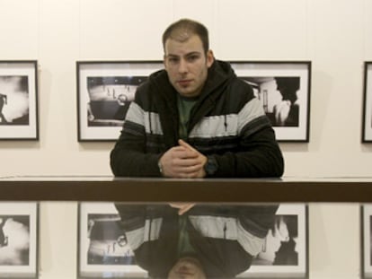 Dimitri Stefanov, junto a las fotografías de su exposición en Madrid.
