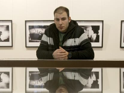 Dimitri Stefanov, junto a las fotografías de su exposición en Madrid.