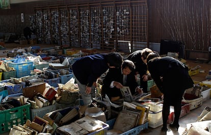 Una familia busca entre álbumes de fotografías recuperados de las zonas devastadas por el terremoto y el tsunami.