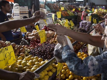 Dos mujeres pagan una bolsa de frutas en el Mercado Central de Buenos Aires