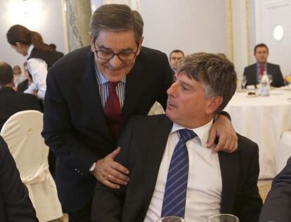 De pie, Mario Fernández, presidente de Kutxabank, saluda a su homólogo en Kutxa, Xabier Iturbe.