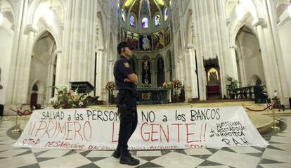 Un agente, ante la pancarta colocada por los manifestantes en el interior del templo.