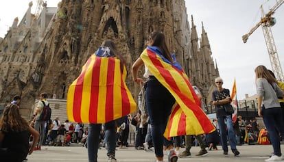 Jovens observam o fechamento do acesso principal da Sagrada Família em Barcelona.