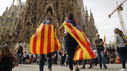 Jovens observam o fechamento do acesso principal da Sagrada Família em Barcelona.