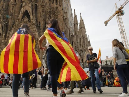 Jovens observam o fechamento do acesso principal da Sagrada Família em Barcelona.