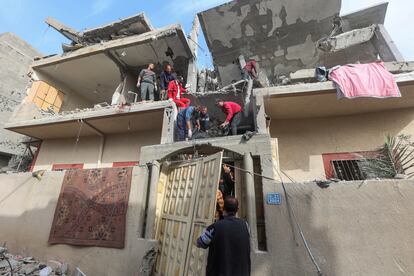 Un grupo de palestinos rescata varios cuerpos de fallecidos en un ataque israelí sobre una casa en Rafah, en Gaza.