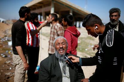 A displaced Iraqi who fled his home has his beard shaved outside Hamam al-Alil camp, south of  Mosul, Iraq, March 10, 2017. Suhaib Salem: "The significance of my picture stems from the fact that after Islamic State captured Mosul in June 2014, it forced all local men to grow long thick beards. So after fleeing across front lines and arriving at the Hamam al-Alil camp run by Iraqi troops, many male refugees queued up for the opportunity to be shorn. I was walking around the camp all day looking for good pictures when I noticed men having their beards shaved off. I ran up and snapped the old man being shaved, though he and others at first refused to let me take pictures as they were still afraid of reprisal if battlefield fortunes shifted and the militants regained control of the area. They were eventually happy and gave me permission to take pictures. I faced challenges every day of my Mosul assignment. Road journeys were long and arduous, with mortar bombs crashing around us frequently and the stench of bodies rotting in the streets where we walked. I have covered wars for Reuters for 19 years and this is the most dangerous one yet." REUTERS/Suhaib Salem/File photo        SEARCH "MOSUL PICTURES" FOR THIS STORY. SEARCH "WIDER IMAGE" FOR ALL STORIES.