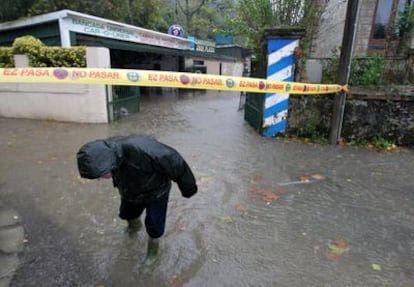 Un vecino camina por el barrio de Martutene de San Sebastián anegado por el desbordamiento del río Urumea.