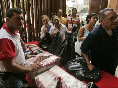 Vecinos de Caracas hacen cola para comprar arroz en un mercado estatal.