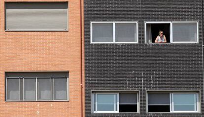 Una vecina se asoma a una ventana del edificio Memoria, de la EMVS, en la calle de Barrileros.