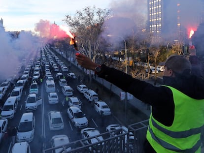 un taxista sujeta unas bengalas durante la protesta, en el paseo de la Castellana de Madrid.