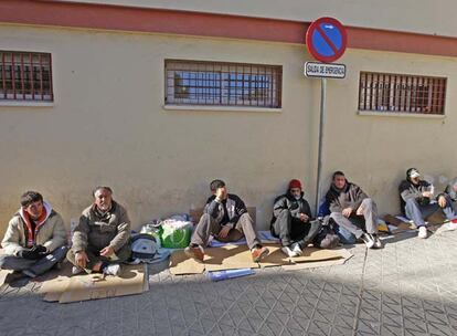 Varios indigentes esperan ayer a la puerta del albergue municipal de Sevilla.