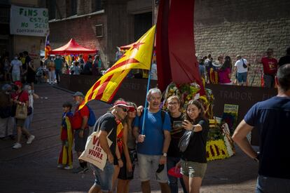 Una familia se fotografía con una 'estelada' en la plaza Fossar de les Moreres de Barcelona.