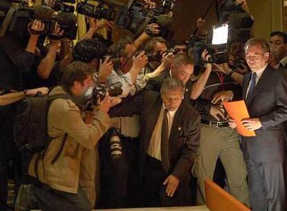 François Bayrou espera, con una carpeta en la mano, a que un miembro de su equipo le abra paso entre los fotógrafos, ayer en París.