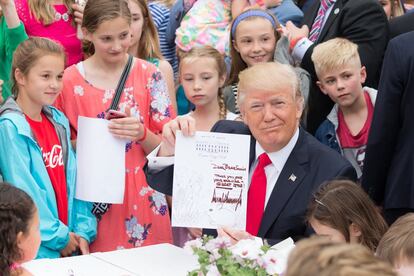 El presidente Donald Trump sostiene una carta firmada que escribió a un miembro de las Fuerzas Armadas de los EEUU, el 17 de abril de 2017, durante el 139 ° 'Easter Egg Roll' en la Casa Blanca, en Washington, D.C.