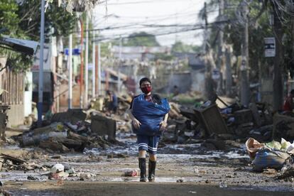 Una persona lleva las pertenencias que recuperó de su casa, que fue dañada por las inundaciones después de que el tifón Vamco golpeara su pueblo hace una semana en Nangka, ciudad de Marikina, Filipinas.