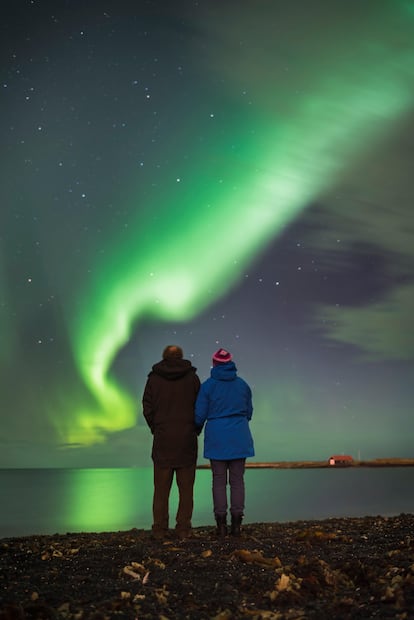 Una pareja observa las auroras boreales en Reykjavik, Islandia.
