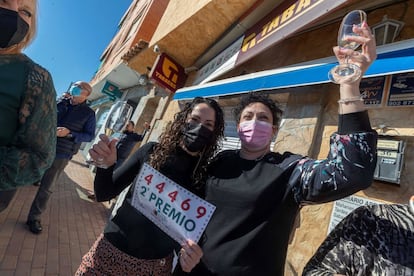 Noelia Garnés (derecha), trabajadora de la administración de lotería de la pedanía murciana de Sangonera la Seca, celebra con una clienta tras vender números del 44.469, agraciado con el segundo premio.