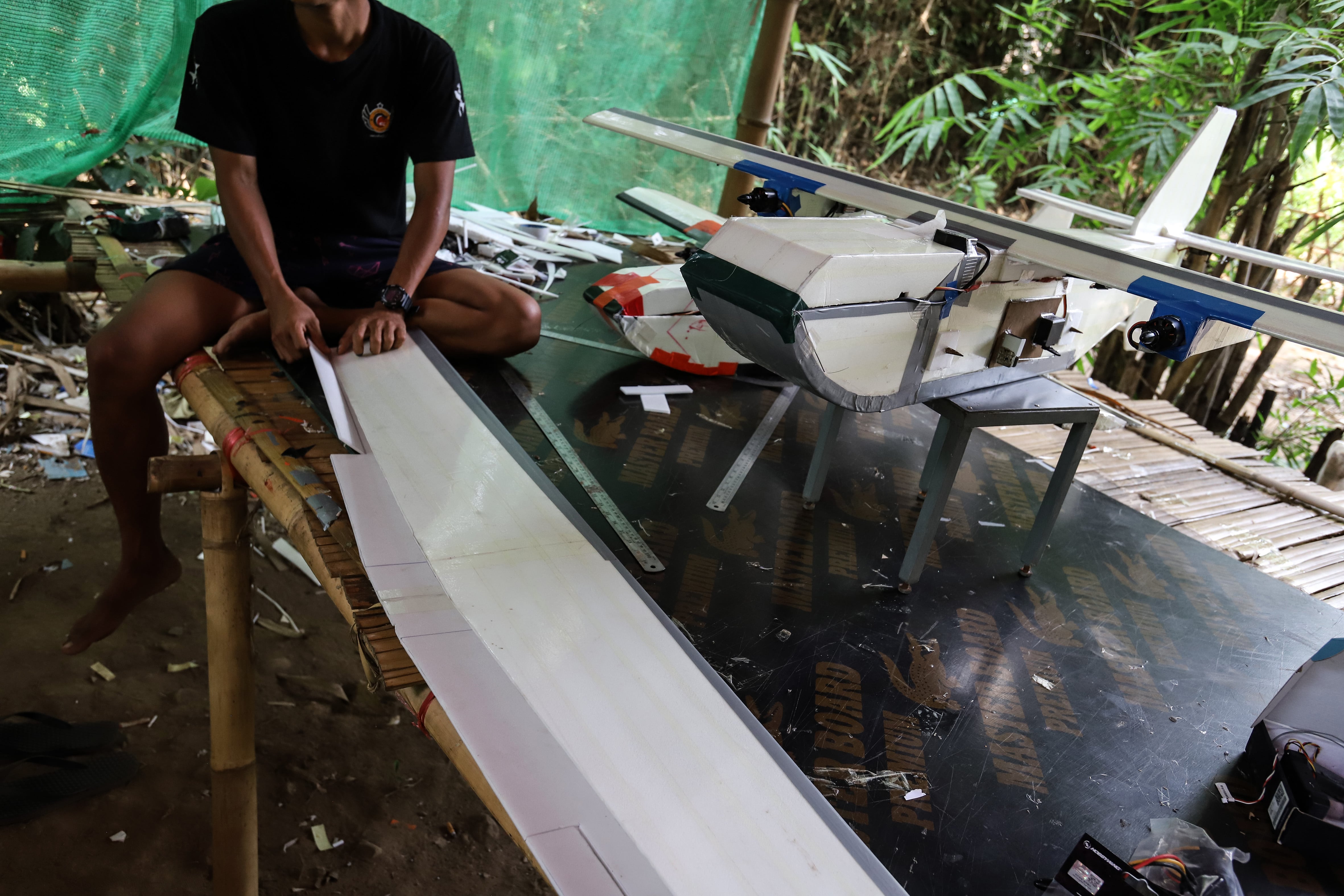 Un combatiente de la Fuerza de Defensa del Pueblo talla un panel de madera para colocarlo en el centro de un dron en un campamento secreto en la selva cerca de la línea del frente en la región de Tanintharyi, Myanmar el 22 de marzo de 2024. 