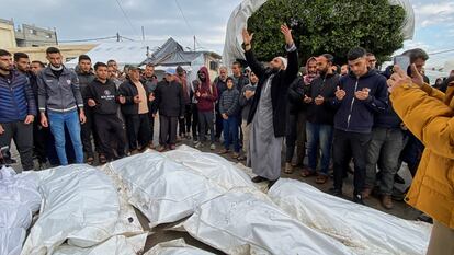 Mourners react next to the bodies of Palestinians killed in Israeli strikes, amid the ongoing conflict between Israel and Hamas, at a hospital in the central Gaza Strip, December 25, 2023.