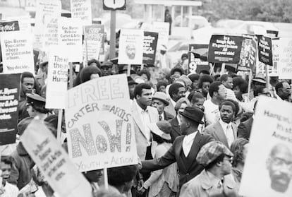 El campeón mundial de pesos pesados Muhammad Ali (centro) encabeza un mitin por las calles de Trenton para instar al gobernador de Nueva Jersey, Brendan Byrne, a perdonar al ex boxeador Rubin 'Hurricane' Carter.