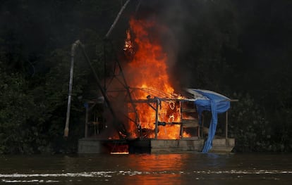 Barco de mineração queima nas margens do rio Uraricoera, durante operação do Ibama.