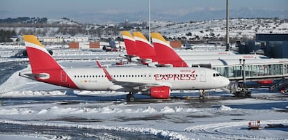 Varios aviones de Iberia e Iberia Express aparcados ayer junto a las pasarelas de acceso de viajeros en la Terminal 4 del aeropuerto de Madrid-Barajas.