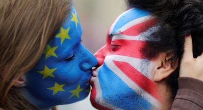 Una pareja se besa con las caras pintadas con las banderas del Reino Unido y la Unión Europea frente a la puerta de Brandeburgo, en Berlín.