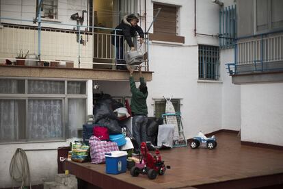 Mercedes Pincay, de 50 años, retira sus pertenencias por la terraza, antes de que la policía antidisturbios la desalojara junto a su pareja de su casa en Madrid.