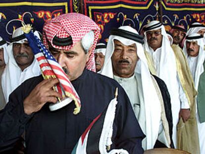 Un líder tribal de Jordania besa la bandera de EE UU antes de firmar en el libro de condolencias de la embajada de ese país en Ammán.