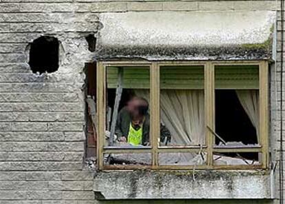 Un agente de la Guardia Civil observa el daño causado por las granadas en la casa cuartel de Urdax (Navarra).