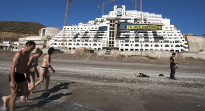 Bañistas pasean ante el hotel El Algarrobico.