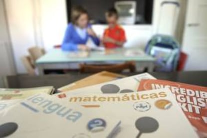 Una madre prepara con su hijo la mochila con los libros en la víspera del comienzo del nuevo curso escolar 2011-2012. EFE/Archivo