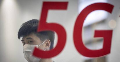 Un hombre se protege con una mascarilla en una tienda de Huawei en Shanghai.