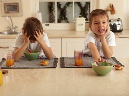 Dos niños muestran su disgusto con la comida que tienen cenar.