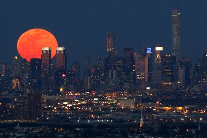 La Lluna plena de color vermell sang durant l'eclipsi més curt del segle s'eleva sobre l'horitzó de la ciutat de Nova York, vista des de West Orange, Nova Jersey.