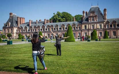 Dos visitantes ante una de las alas del palacio de Fontainebleau, a las afueras de París.