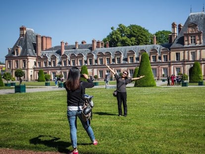 Dos visitantes ante una de las alas del palacio de Fontainebleau, a las afueras de París.