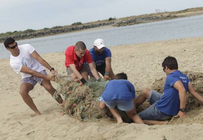 Voluntarios retirando residuos de una playa de Punta Umbría (Huelva).