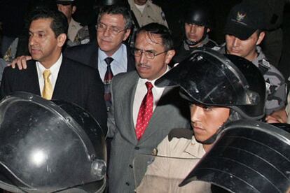Policías ecuatoreños escoltan al ex-presidente Lucio Gutierrez a su llegada al aeropuerto militar de Manta.