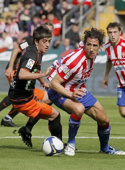 El sportinguista Camacho se lleva el balón ante Pablo Hernández.