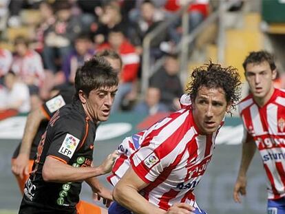 El sportinguista Camacho se lleva el balón ante Pablo Hernández.